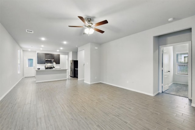 25707 Hickory Pecan Trl, Tomball, TX 77375 - unfurnished living room featuring ceiling fan, baseboards, recessed lighting, and light wood-type flooring