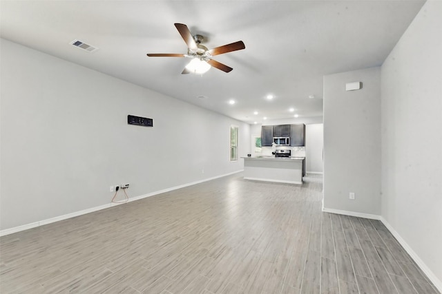 25707 Hickory Pecan Trl, Tomball, TX 77375 - unfurnished living room with a ceiling fan, light wood-style floors, baseboards, and recessed lighting