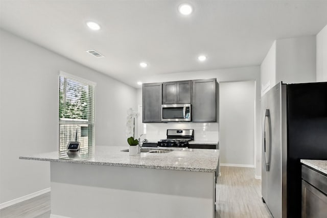25707 Hickory Pecan Trl, Tomball, TX 77375 - kitchen with stainless steel appliances, a sink, light wood-style floors, baseboards, and recessed lighting