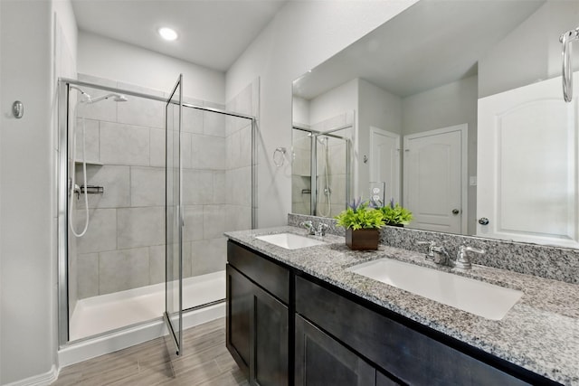 25707 Hickory Pecan Trl, Tomball, TX 77375 - full bathroom featuring a stall shower, double vanity, and wood finished floors