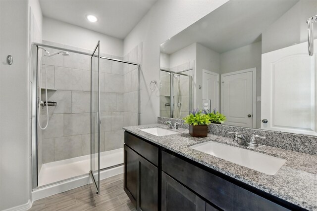 25707 Hickory Pecan Trl, Tomball, TX 77375 - full bath featuring a shower stall, double vanity, and wood finished floors