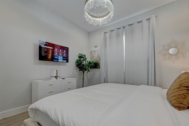 2105 Sam Wilson St Unit C, Houston, TX 77020 - bedroom featuring light wood-style flooring, baseboards, and a chandelier