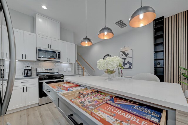 2105 Sam Wilson St Unit C, Houston, TX 77020 - kitchen with appliances with stainless steel finishes, light wood-type flooring, backsplash, white cabinets, and recessed lighting