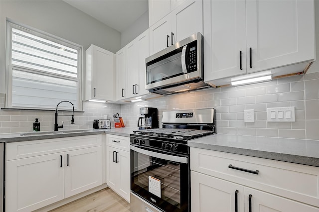 2105 Sam Wilson St Unit C, Houston, TX 77020 - kitchen with stainless steel appliances, a sink, white cabinets, and tasteful backsplash