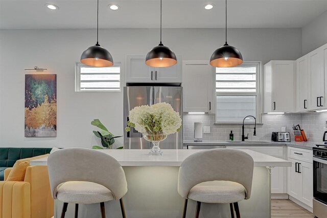 2105 Sam Wilson St Unit C, Houston, TX 77020 - kitchen with stainless steel appliances, a sink, a kitchen bar, decorative backsplash, and light countertops