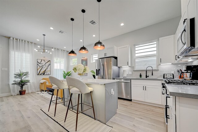 2105 Sam Wilson St Unit C, Houston, TX 77020 - kitchen with appliances with stainless steel finishes, a sink, a kitchen island, a kitchen bar, and tasteful backsplash
