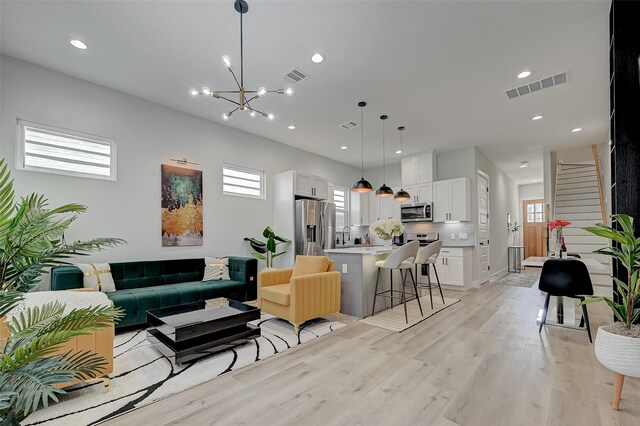 2105 Sam Wilson St Unit C, Houston, TX 77020 - living area featuring plenty of natural light, light wood-type flooring, a chandelier, and recessed lighting