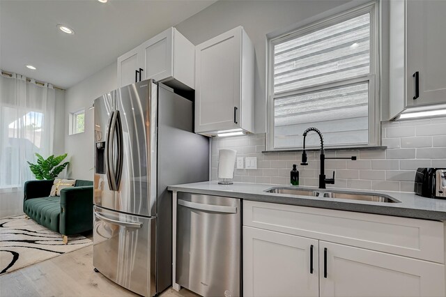 2105 Sam Wilson St Unit C, Houston, TX 77020 - kitchen featuring appliances with stainless steel finishes, a sink, tasteful backsplash, white cabinetry, and recessed lighting