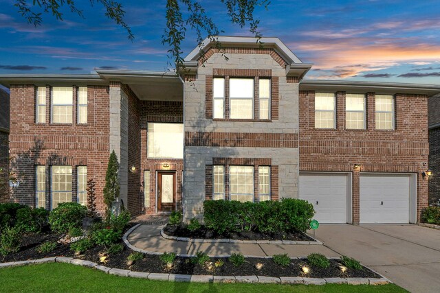 14311 Lakepointe Bend Ln, Cypress, TX 77429 - view of front facade featuring driveway, an attached garage, stone siding, and brick siding