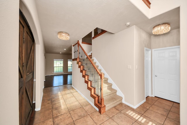 14311 Lakepointe Bend Ln, Cypress, TX 77429 - entrance foyer with a chandelier, light tile patterned floors, stairs, and baseboards