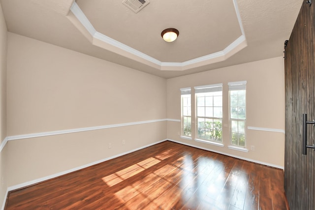 14311 Lakepointe Bend Ln, Cypress, TX 77429 - empty room featuring a raised ceiling, a barn door, wood-type flooring, baseboards, and crown molding