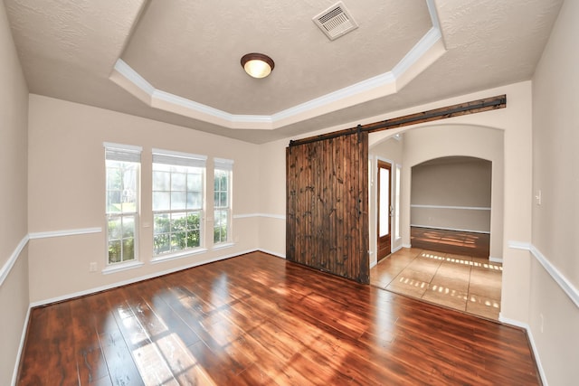 14311 Lakepointe Bend Ln, Cypress, TX 77429 - unfurnished bedroom featuring a raised ceiling, a barn door, hardwood / wood-style flooring, arched walkways, and crown molding