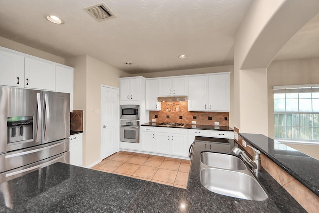 14311 Lakepointe Bend Ln, Cypress, TX 77429 - kitchen with stainless steel appliances, under cabinet range hood, a sink, backsplash, and white cabinetry