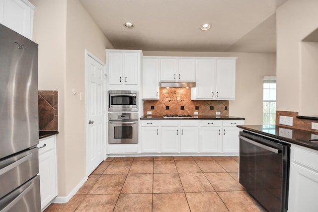 14311 Lakepointe Bend Ln, Cypress, TX 77429 - kitchen with stainless steel appliances, dark countertops, under cabinet range hood, tasteful backsplash, and white cabinets