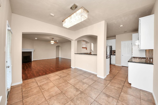 14311 Lakepointe Bend Ln, Cypress, TX 77429 - kitchen featuring dark countertops, freestanding refrigerator, ceiling fan, white cabinets, and light tile patterned flooring