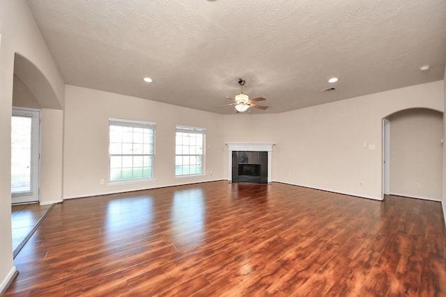 14311 Lakepointe Bend Ln, Cypress, TX 77429 - unfurnished living room with arched walkways, a ceiling fan, wood finished floors, recessed lighting, and a tiled fireplace