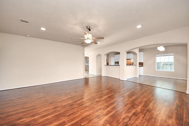 14311 Lakepointe Bend Ln, Cypress, TX 77429 - unfurnished living room featuring a ceiling fan, dark wood-style floors, arched walkways, recessed lighting, and baseboards
