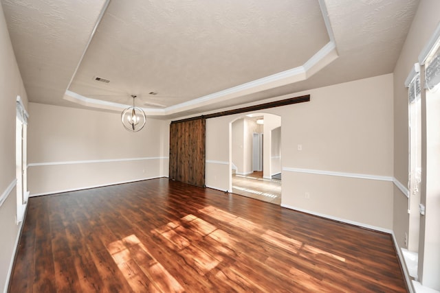 14311 Lakepointe Bend Ln, Cypress, TX 77429 - unfurnished room featuring a tray ceiling, arched walkways, wood finished floors, a chandelier, and a barn door