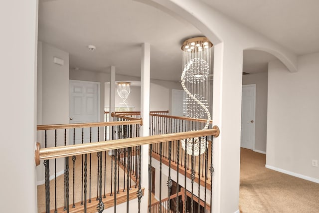 14311 Lakepointe Bend Ln, Cypress, TX 77429 - hallway featuring an upstairs landing, a chandelier, carpet flooring, baseboards, and arched walkways