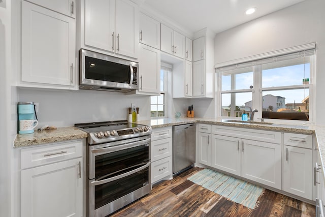 22516 Bay Point Dr, Galveston, TX 77554 - kitchen with appliances with stainless steel finishes, a sink, white cabinets, dark wood finished floors, and recessed lighting