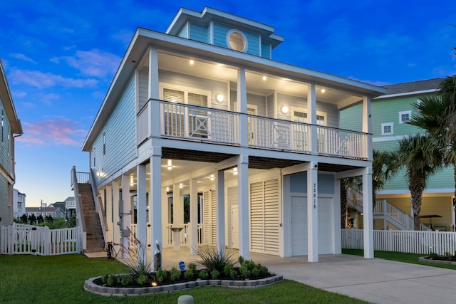 22516 Bay Point Dr, Galveston, TX 77554 - view of front facade featuring a garage, a balcony, concrete driveway, and stairs