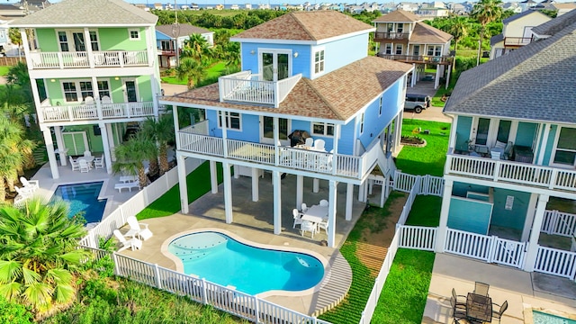 22516 Bay Point Dr, Galveston, TX 77554 - back of property with a balcony, roof with shingles, a fenced backyard, a residential view, and a patio