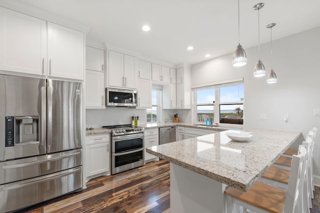 22516 Bay Point Dr, Galveston, TX 77554 - kitchen featuring appliances with stainless steel finishes, a peninsula, dark wood-style flooring, white cabinets, and a sink