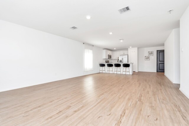 18110 Mendocino Ridge Ln, Hockley, TX 77447 - unfurnished living room featuring light wood-type flooring and recessed lighting