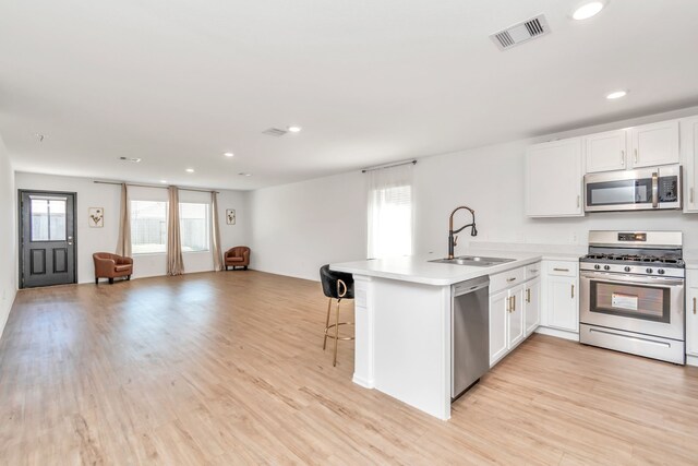 18110 Mendocino Ridge Ln, Hockley, TX 77447 - kitchen featuring appliances with stainless steel finishes, a sink, open floor plan, a peninsula, and a kitchen bar
