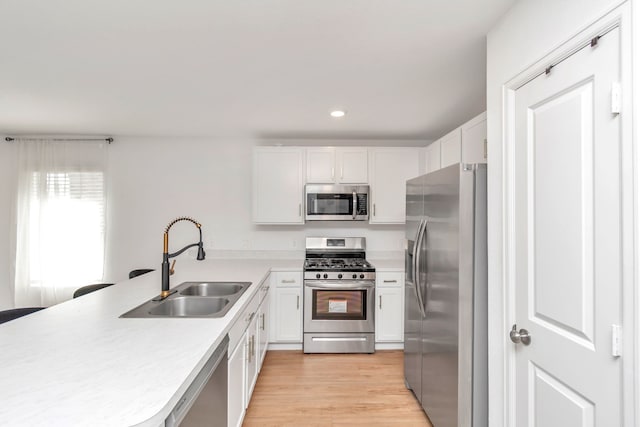 18110 Mendocino Ridge Ln, Hockley, TX 77447 - kitchen with appliances with stainless steel finishes, a sink, a peninsula, light countertops, and white cabinetry