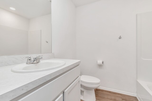 18110 Mendocino Ridge Ln, Hockley, TX 77447 - bathroom with vanity, wood finished floors, toilet, and baseboards