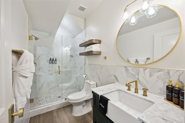 5004 Park Dr, Houston, TX 77023 - full bath featuring a marble finish shower, vanity, tile walls, wood finished floors, and wainscoting