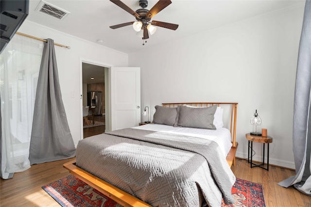 5004 Park Dr, Houston, TX 77023 - bedroom with wood finished floors, stainless steel refrigerator with ice dispenser, and a ceiling fan