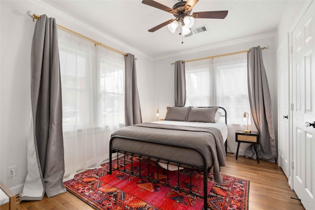 5004 Park Dr, Houston, TX 77023 - bedroom featuring multiple windows, wood finished floors, crown molding, and a ceiling fan