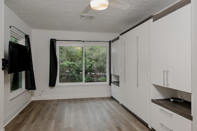 3 Meadow Beauty, The Woodlands, TX 77381 - empty room featuring a textured ceiling, light wood finished floors, baseboards, and a ceiling fan