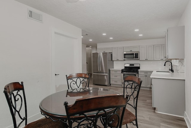 3 Meadow Beauty, The Woodlands, TX 77381 - dining area featuring light wood-style flooring, a textured ceiling, recessed lighting, and baseboards