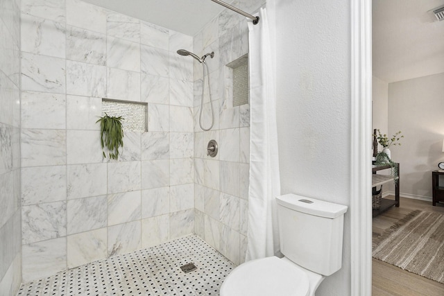 5927 Maco St, Galveston, TX 77551 - full bathroom featuring a tile shower, toilet, and wood finished floors