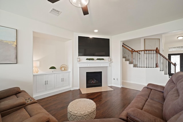 20719 Kerby Pl, Cypress, TX 77433 - living room with a ceiling fan, stairway, dark wood-style flooring, and a fireplace with flush hearth