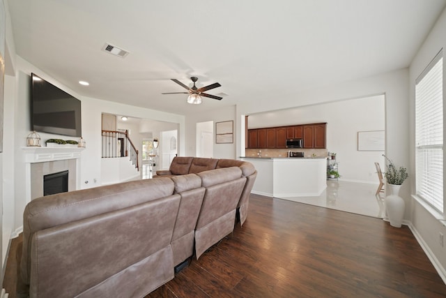 20719 Kerby Pl, Cypress, TX 77433 - living room featuring stairway, dark wood-style flooring, a tile fireplace, and healthy amount of natural light