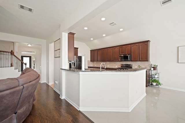 20719 Kerby Pl, Cypress, TX 77433 - kitchen featuring appliances with stainless steel finishes, open floor plan, backsplash, dark stone countertops, and baseboards