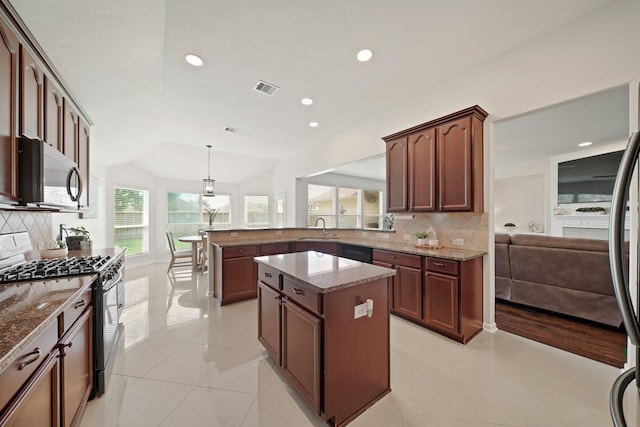 20719 Kerby Pl, Cypress, TX 77433 - kitchen with stainless steel appliances, a sink, light stone countertops, a peninsula, and decorative backsplash