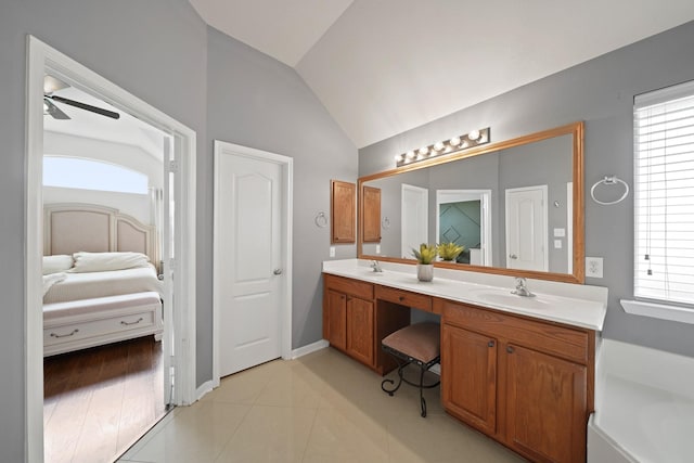 20719 Kerby Pl, Cypress, TX 77433 - ensuite bathroom featuring double vanity, vaulted ceiling, a ceiling fan, tile patterned floors, and baseboards