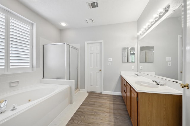 13819 Marbledale Ct, Houston, TX 77059 - bathroom featuring a shower stall, a whirlpool tub, double vanity, wood finished floors, and baseboards