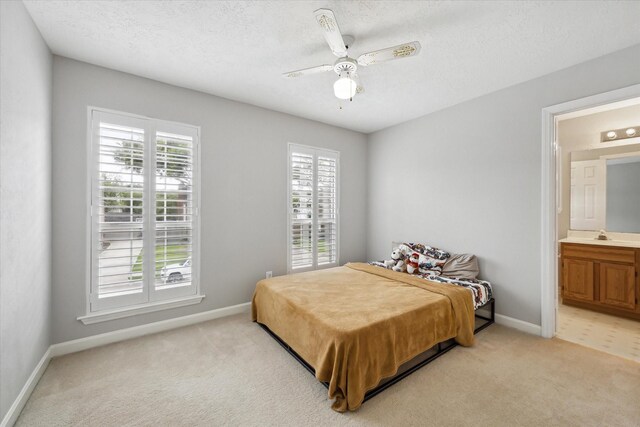 13819 Marbledale Ct, Houston, TX 77059 - bedroom featuring light carpet, baseboards, ensuite bathroom, a textured ceiling, and ceiling fan