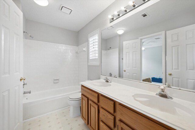 13819 Marbledale Ct, Houston, TX 77059 - bathroom featuring double vanity, shower / tub combination, tile patterned floors, toilet, and a ceiling fan