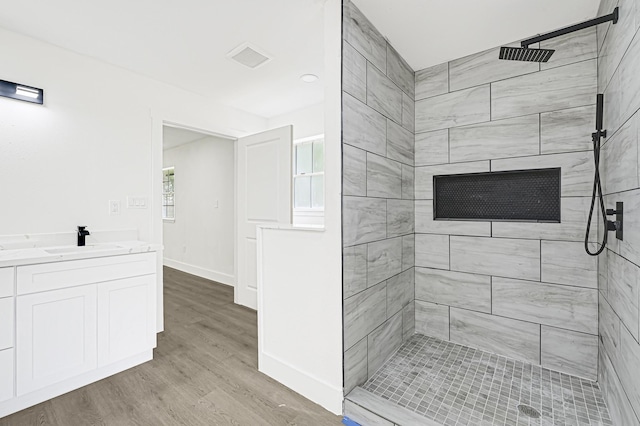 124 Rolling Wood Dr, Baytown, TX 77520 - full bath with a tile shower, wood finished floors, vanity, and baseboards