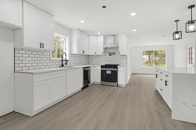 124 Rolling Wood Dr, Baytown, TX 77520 - kitchen featuring gas range oven, a sink, dishwasher, wall chimney range hood, and light wood-style flooring