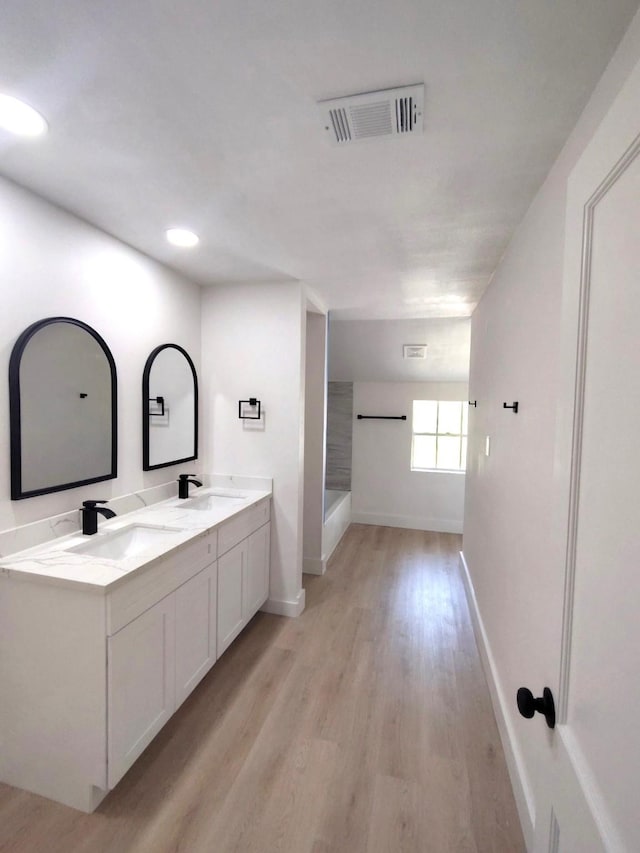 124 Rolling Wood Dr, Baytown, TX 77520 - bathroom with baseboards, wood finished floors, double vanity, and a shower