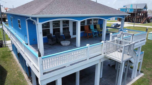 2108 Mills, Crystal Beach, TX 77650 - back of house featuring roof with shingles, a wooden deck, and a lawn