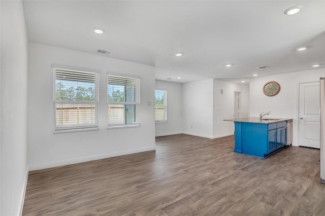 11947 Midas Ln, Willis, TX 77378 - unfurnished living room featuring a sink, wood finished floors, recessed lighting, and baseboards